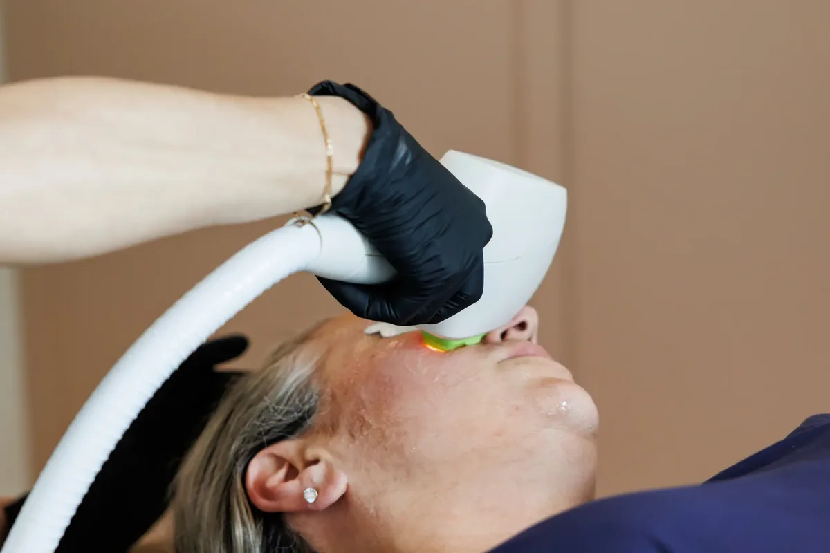 Provider performing a laser facial treatment at Alchemy Beauty.