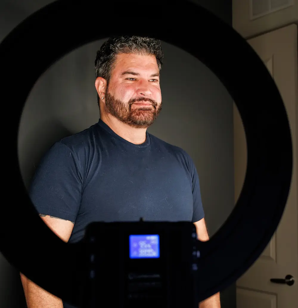 Portrait of a team member framed through a ring light at Alchemy Beauty.