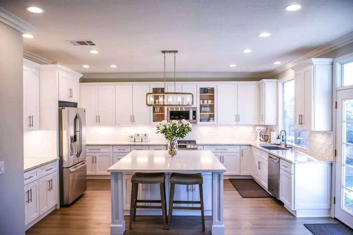 White kitchen with recessed lighting and updated fixtures from the Bechtold Electric site.
