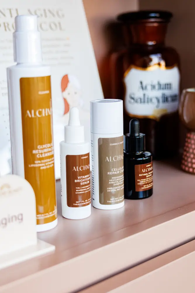 Alchemy skincare products displayed on a treatment-room shelf.